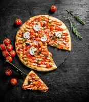 Sliced Mexican pizza with cherry tomatoes and rosemary. photo