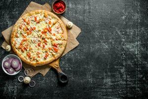 Pizza with tomatoes, chicken and onion slices. photo