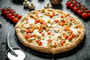 Pizza with tomatoes, chicken and cheese. photo