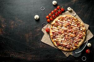 Barbecue pizza on paper with cherry tomatoes. photo