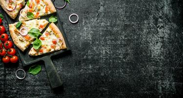 Slices of pizza with tomatoes on a branch and spinach. photo