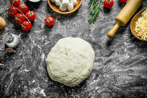 Raw pizza. Dough with different ingredients for cooking homemade pizza. photo
