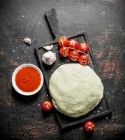 Dough with cherry tomatoes and garlic. photo