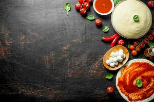 Dough with different ingredients for homemade pizza. photo