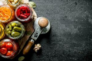 Assortment of different preserved food in glass jars on paper. photo