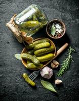 Pickled cucumbers on a plate and in a glass jar. photo