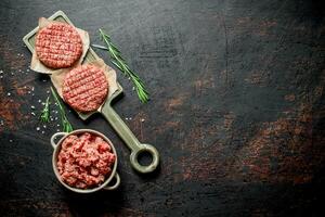 Raw burgers with ground beef and rosemary. photo