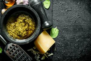 Pesto sauce on a stone Board with Basil, oil and Parmesan. photo