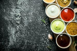 Different sauces in the bowls on the cutting Board. photo