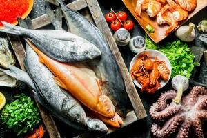 Sea fish on tray with octopus, herbs and garlic. photo