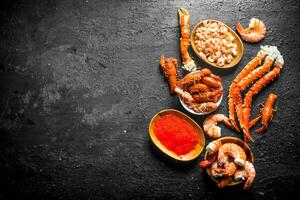 Seafood. Plates with boiled crayfish, shrimp, crab and caviar. photo