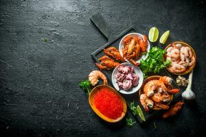 caviar y Mariscos en un corte tablero con hierbas y Lima rebanadas foto