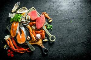 Salmon and tuna steaks with a variety of seafood and herbs. photo