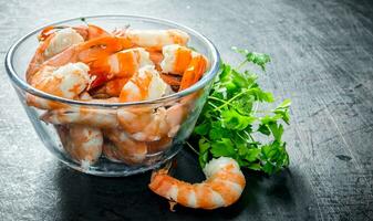 Cooked shrimps in a bowl with greens. photo