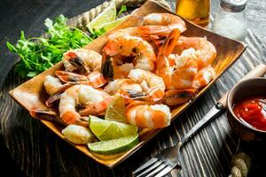 Shrimps on tray with parsley, lime slices and onion rings. photo