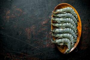 Raw shrimps on a wooden plate. photo