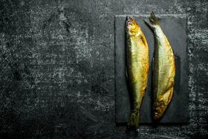 Smoked fish on a stone Board. photo