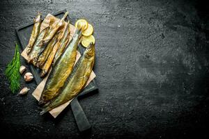 fragante ahumado pescado con hierbas, ajo rebanadas y limón rebanadas foto