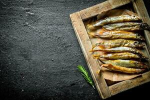 Smoked fish on the tray with the rosemary. photo