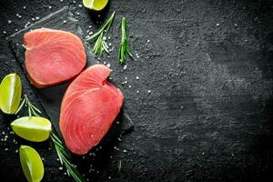 Fresh raw tuna steak with lime and rosemary. photo