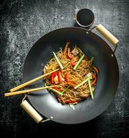 Chinese wok. Asian cellophane noodles with vegetables and chicken in a frying pan wok. photo