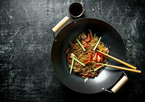 Chinese wok. Asian cellophane noodles with vegetables and chicken in a frying pan wok. photo