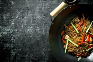 Chinese wok. Asian cellophane noodles with vegetables and chicken in a frying pan wok. photo