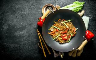 Chinese wok. Ready funchoza noodles with vegetables and ingredients for its preparation. photo