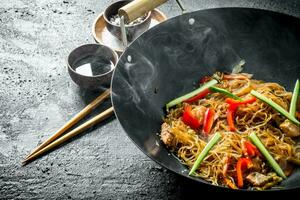 Chinese wok. Hot Asian cellophane noodles in a frying pan wok. photo