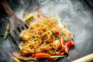 Hot Asian cellophane noodles with vegetables and salmon. photo