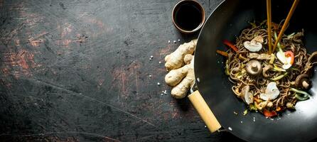 Fragrant soba noodles in a wok pan with mushrooms and fresh vegetables. photo