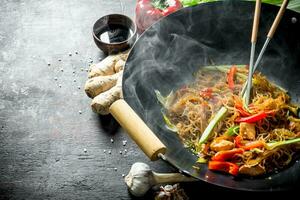 Freshly cooked Chinese noodles wok funchoza with salmon, vegetables and sauce. photo