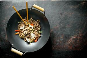 Freshly cooked Chinese soba noodles in a wok pan. photo