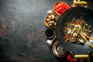 Chinese soba noodles in wok pan with ginger, spices, soy sauce, garlic and vegetables. photo