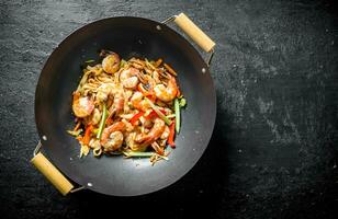 chino wok asiático udon tallarines con camarón y vegetales. foto