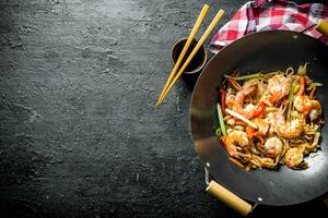 Delicious Chinese wok Udon noodles with fresh vegetables, sauce and shrimp. photo