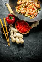 Chinese wok. Freshly cooked Udon noodles with ginger and soy sauce in bowls. photo