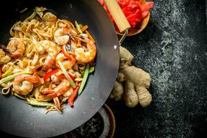 Chinese wok pasta with shrimp and fresh vegetables. photo