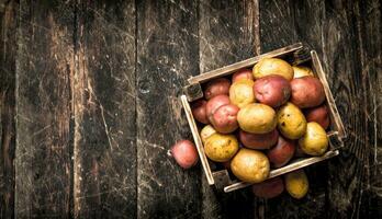 Fresh potatoes in a wooden box. photo