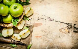 Fresh green apples in the basket with knife . photo