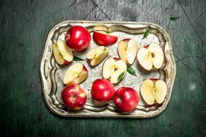 rojo manzanas en un acero bandeja con hojas. foto