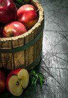 Red apples in a wooden bucket. photo