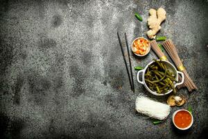 asiático alimento. un variedad de ingredientes para Cocinando chino o tailandés comida en un rústico antecedentes . foto