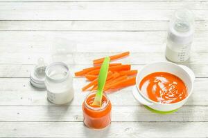 Baby food. Baby carrot puree with milk in a bottle. photo