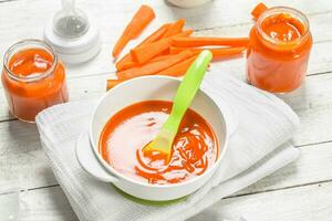 Baby food. Baby carrot puree with milk in a bottle. photo