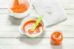 Baby food. Baby puree from fresh carrots with a spoon. photo