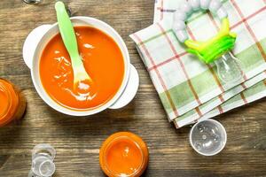 Baby food. Baby puree carrot with a nipple. photo