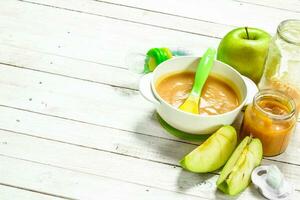 Baby food. Baby puree from fresh green apples. photo