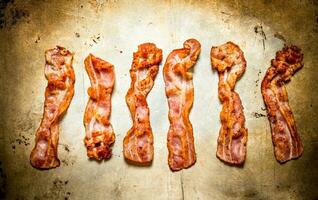 Fried bacon. On old rustic background. photo