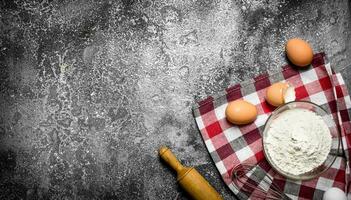 Baking background. Flour and fresh eggs for baking on rustic background . photo